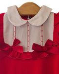 Red baby sleepsuit with embroidered bib and bows