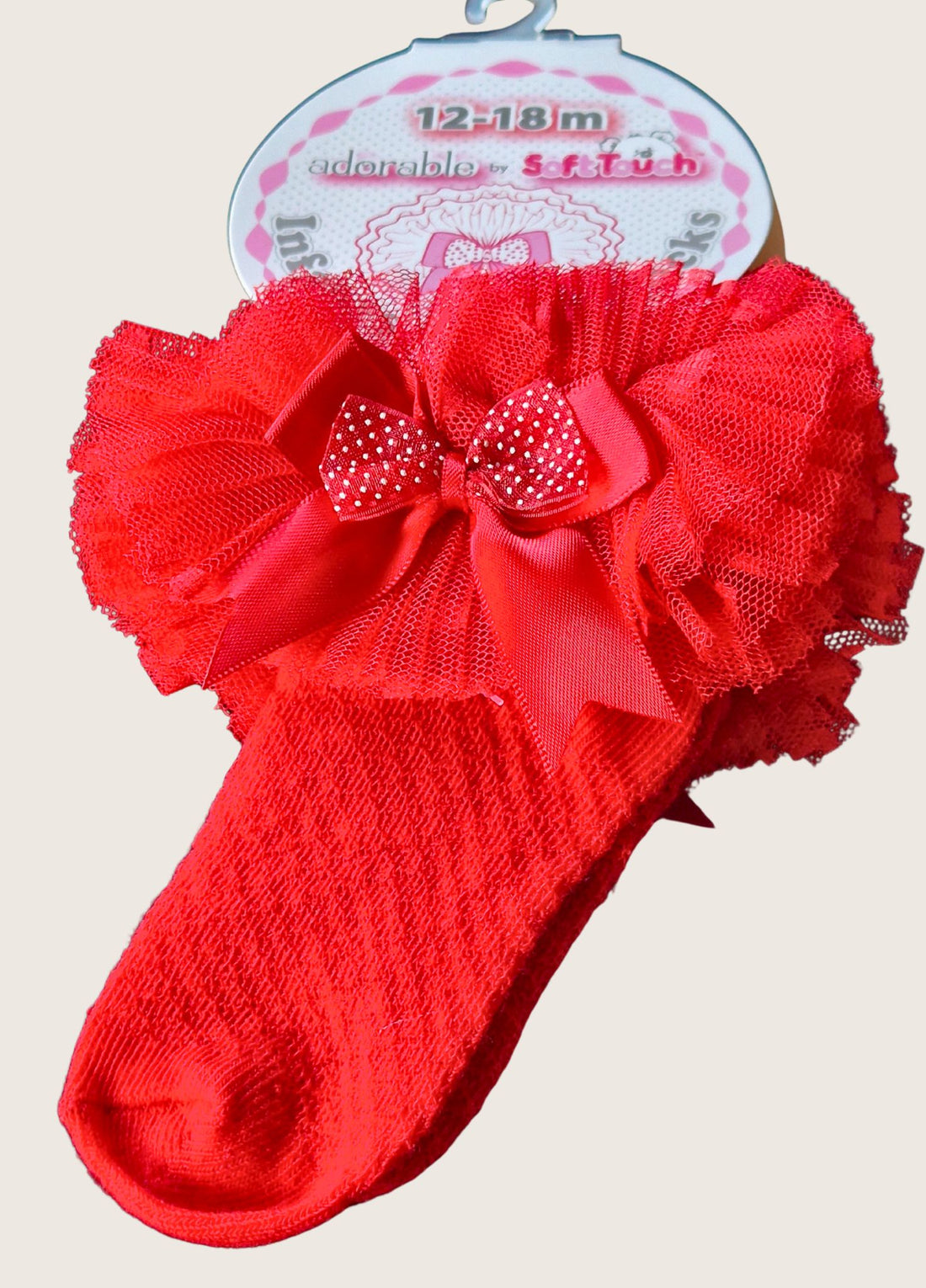 Red baby sock with tutu tulle frill and bow on a white background