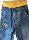 Close-up of boys blue jeans with the dog applique in the pocket 