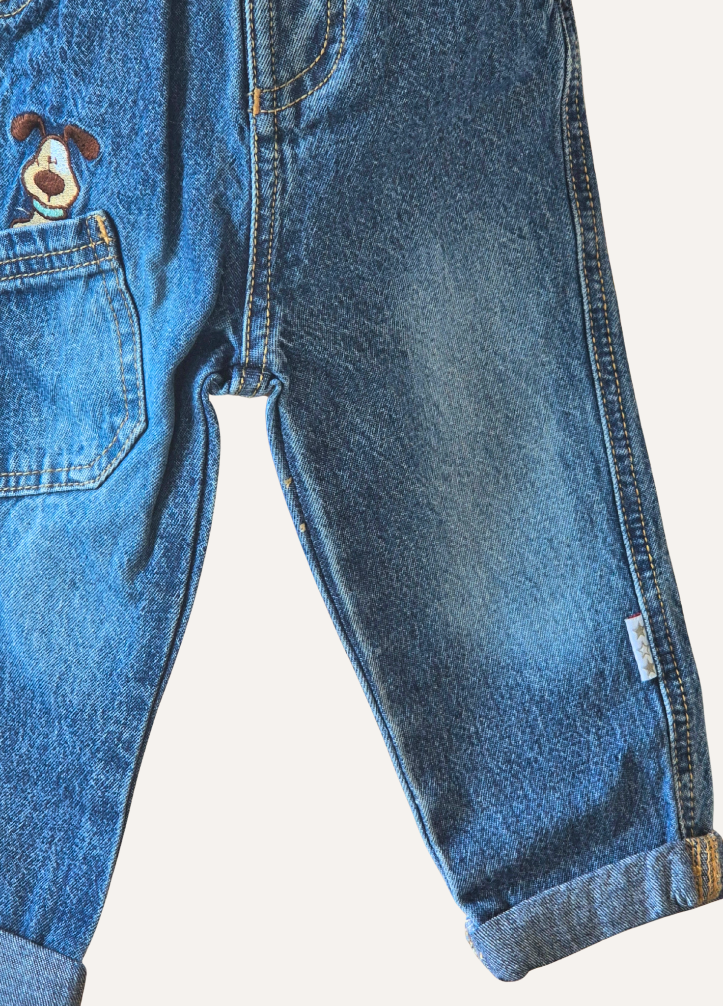 Close up of the boys blue distressed jeans with dog applique