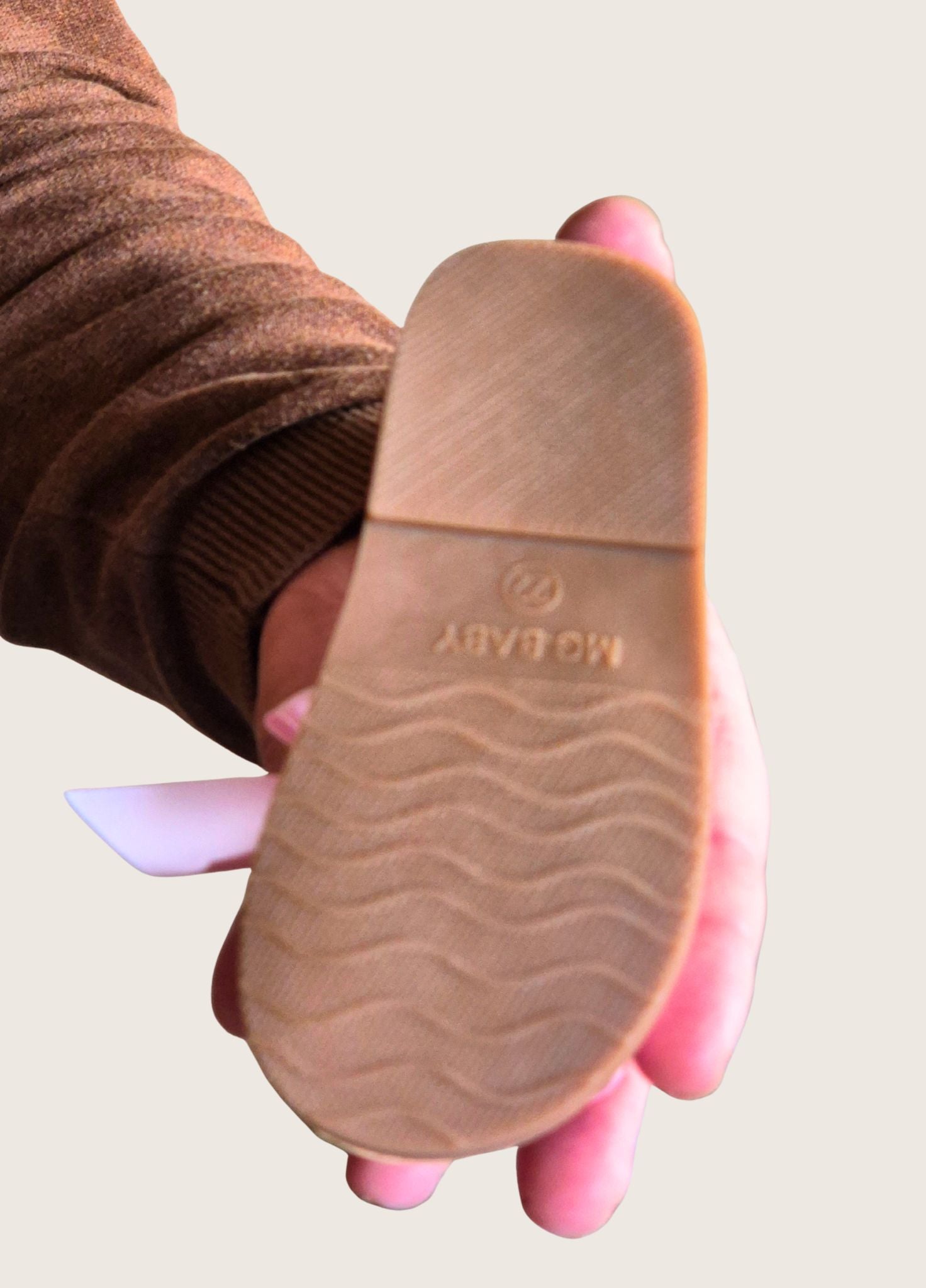 sandal held in a hand showing the hard sole.